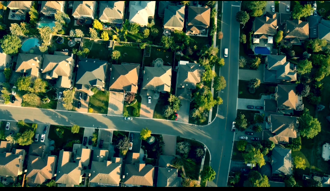 Aerial view of residential neighborhood in wildland-urban interface showing properties at highest wildfire risk with defensible space and vegetation management needs